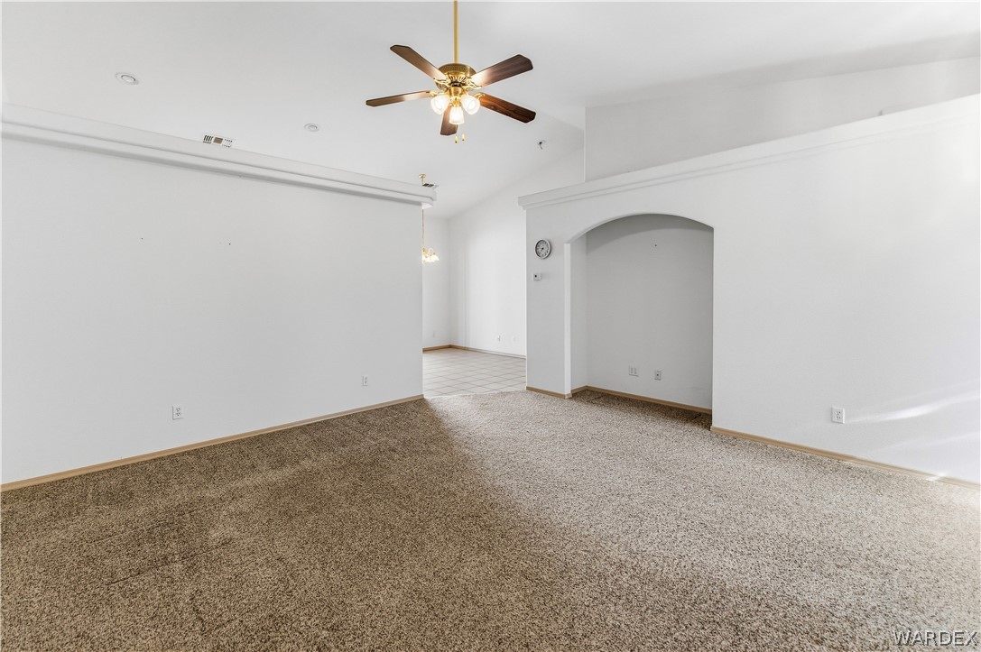 3973 Prairie View Drive Kingman, AZ 86409 - Photo 12 of 34 Spacious room featuring vaulted ceilings, a ceiling fan with integrated lighting, recessed lighting, and an arched wall niche