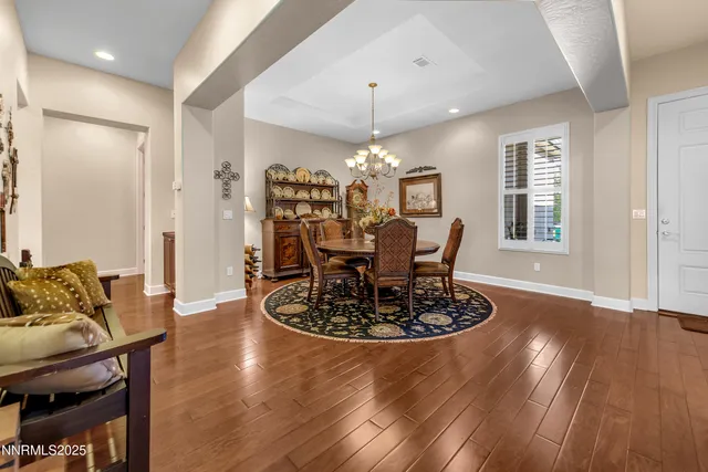 a view of a dining room with furniture a chandelier and wooden floor