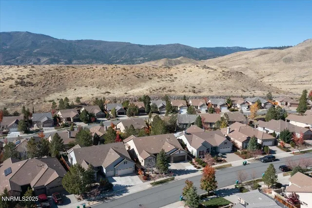 a view of a white house with a yard and wooden fence
