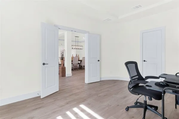 a view of a workspace with furniture and wooden floor