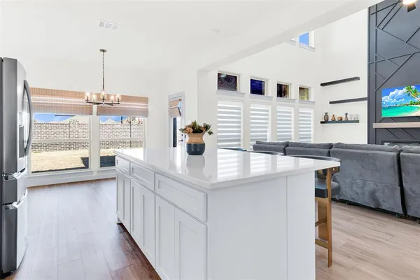 a kitchen with stainless steel appliances kitchen island granite countertop a sink a stove and a wooden floors