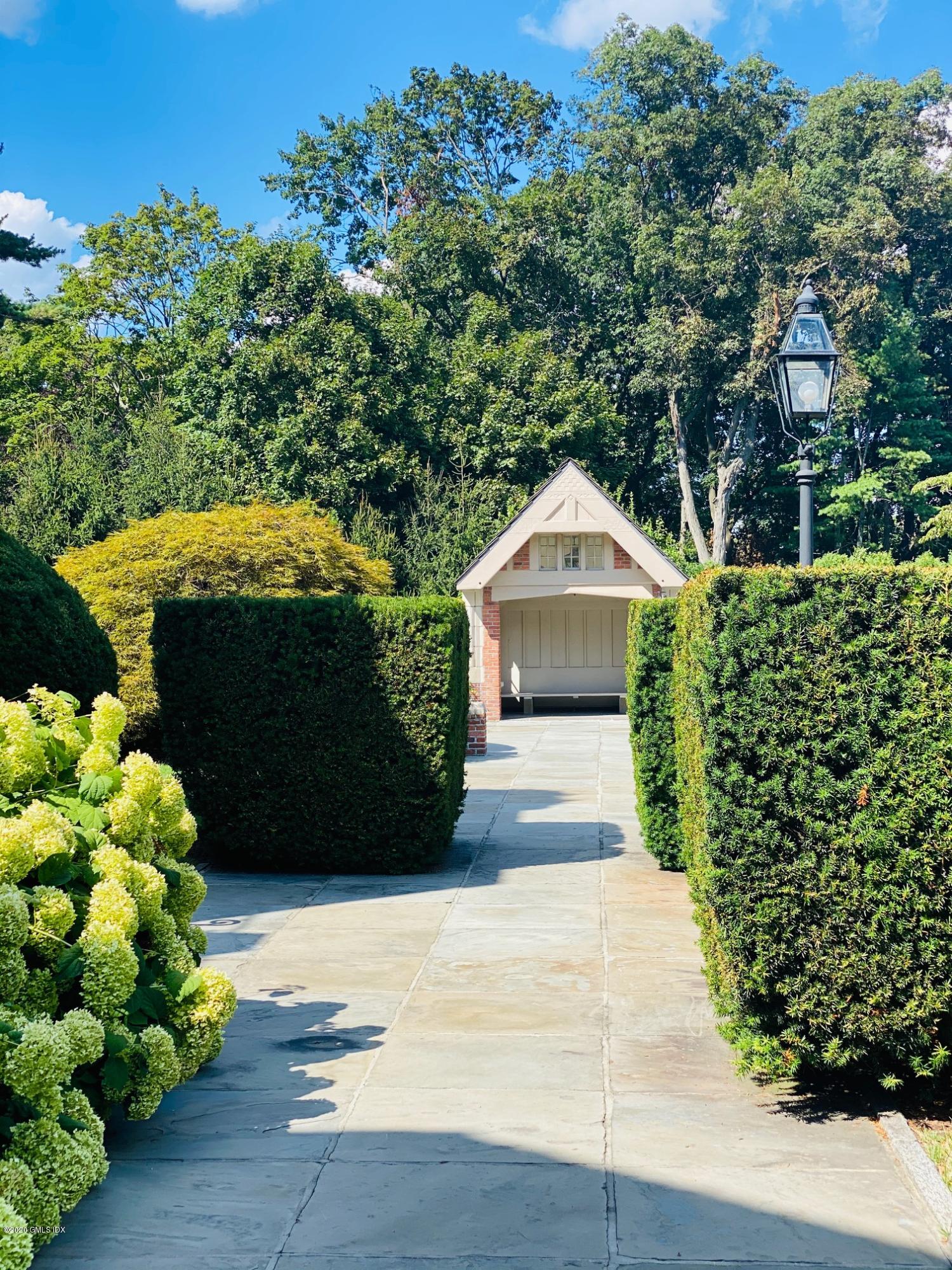 460 North Street Greenwich, CT 06830 - Photo 24 of 25 a front view of a house with a yard and a garden