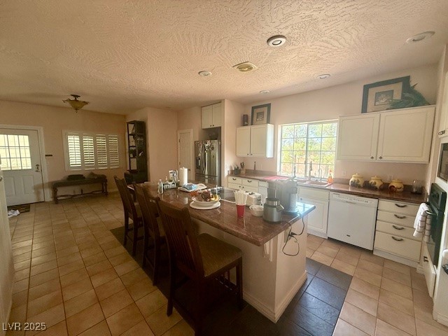 10561 Rancho Destino Road Las Vegas, NV 89183 - Photo 11 of 29 Kitchen featuring a textured ceiling, white cabinetry, and white appliances