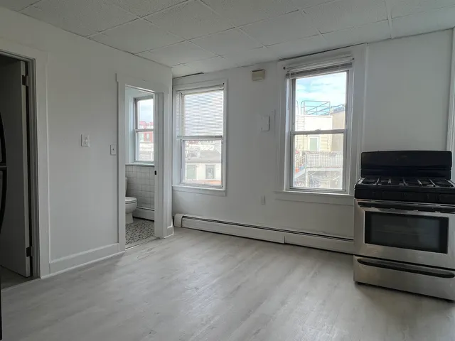 an empty room with windows and fireplace