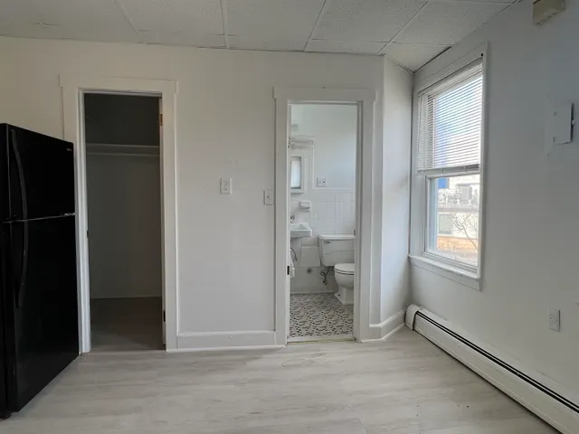 an empty room with windows and a bathroom