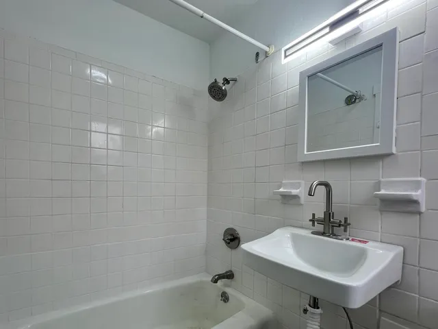 a bathroom with a sink a shower and mirror