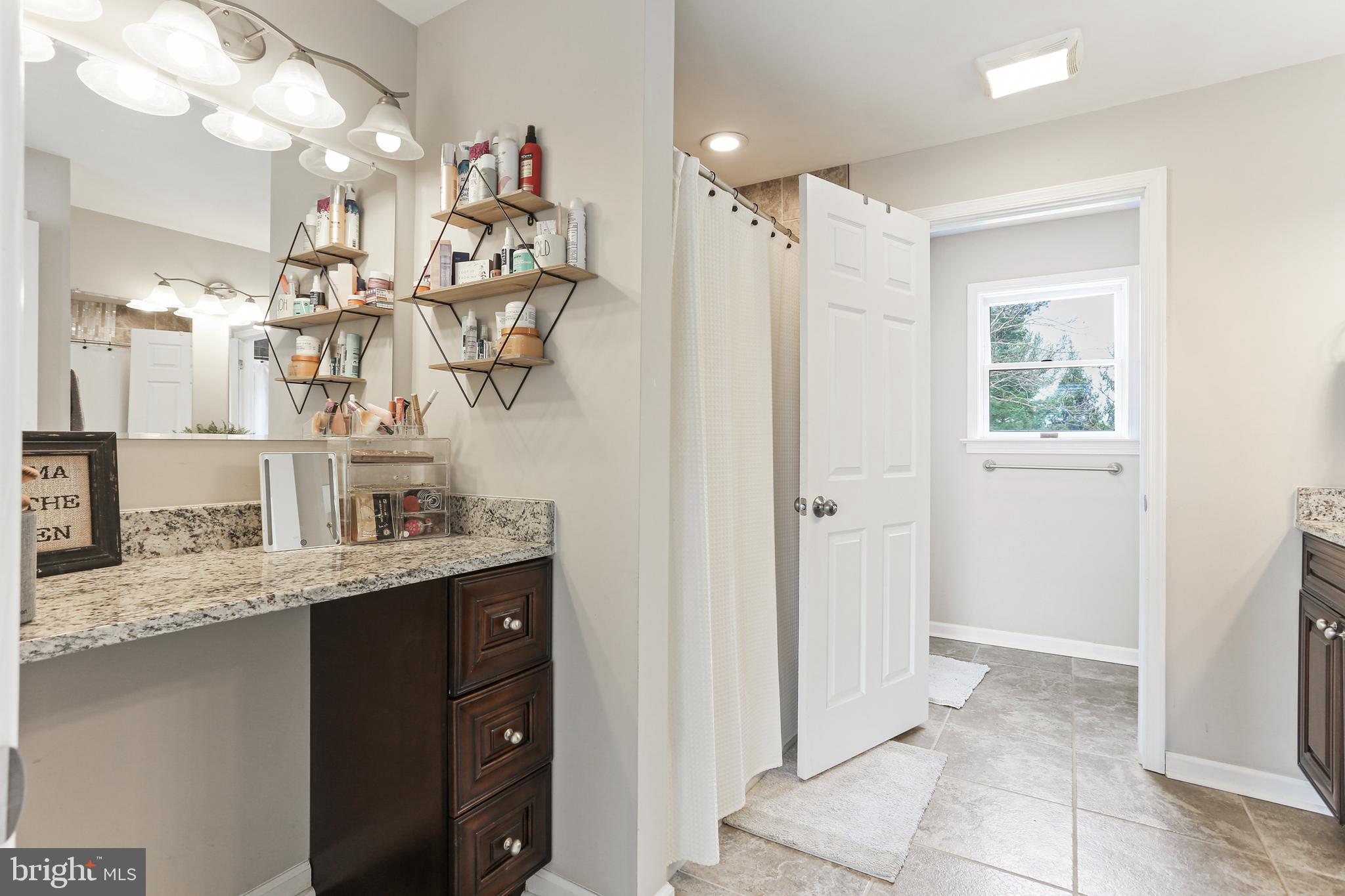 3234 Bidle Road Middletown, MD 21769 - Photo 20 of 45 a bathroom with a granite countertop sink a mirror and shower