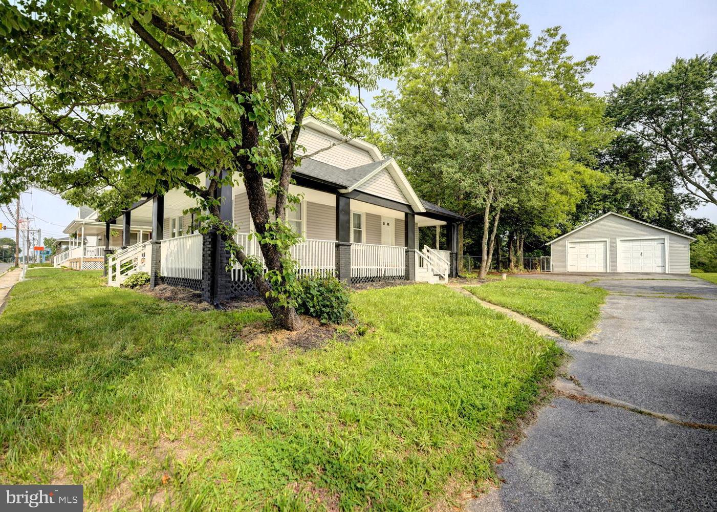 a front view of a house with a yard and trees