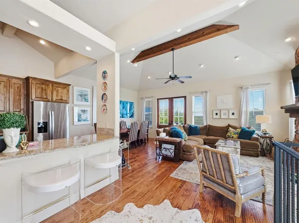 a living room with furniture wooden floor and a large window