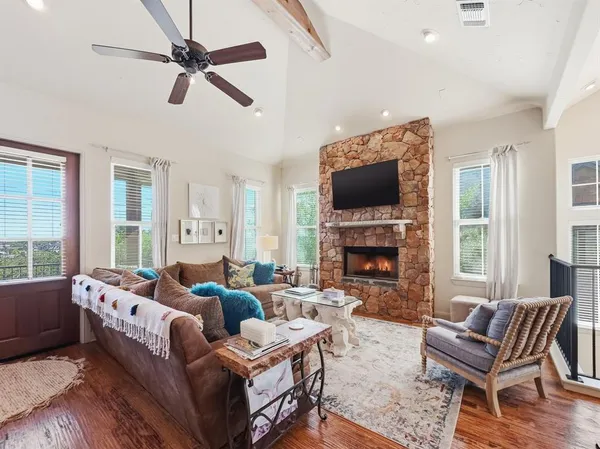 a living room with furniture a fireplace and a flat screen tv