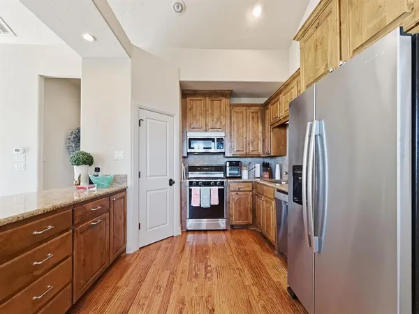 a kitchen with granite countertop stainless steel appliances a counter top space and cabinets