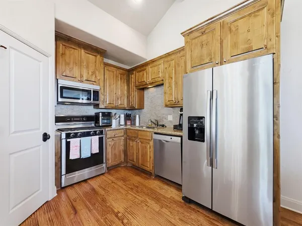 a kitchen with stainless steel appliances granite countertop a refrigerator and a stove top oven