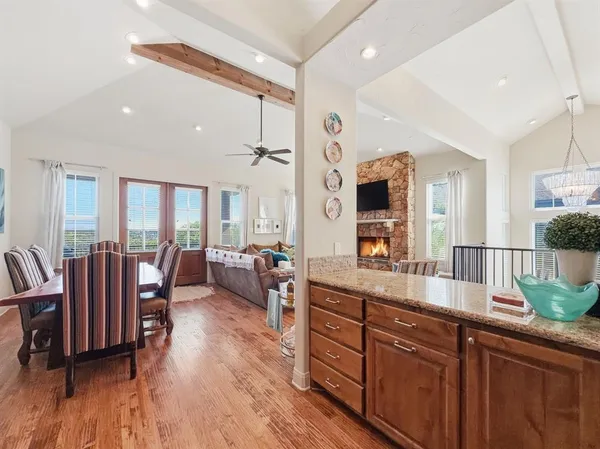 a large living room with stainless steel appliances granite countertop furniture a large window and wooden floors