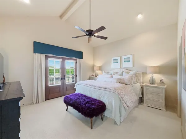 a bedroom with a large bed and a chandelier
