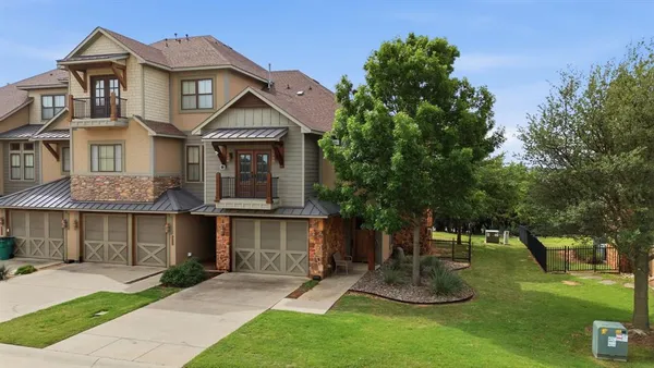 a front view of a house with a yard and trees