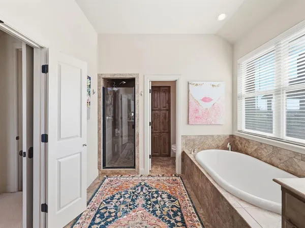 a bathroom with a tub sink and mirror