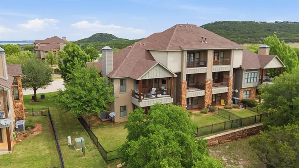 a aerial view of a house with table and chairs under an umbrella
