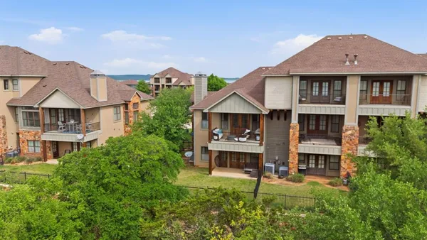 a front view of a residential apartment building with a yard