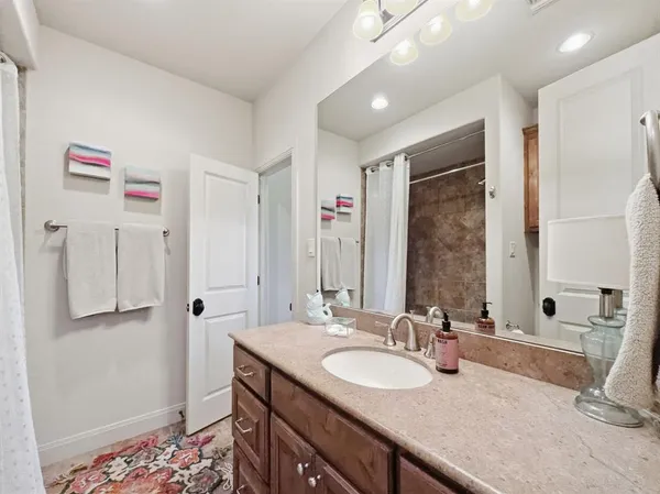 a bathroom with a granite countertop sink and a mirror