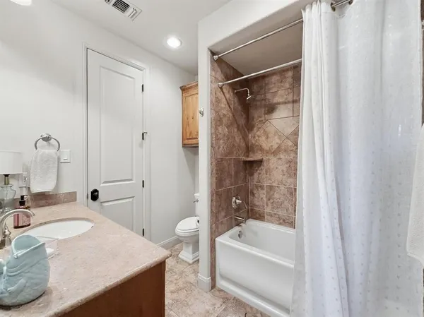 a bathroom with a granite countertop sink toilet and shower