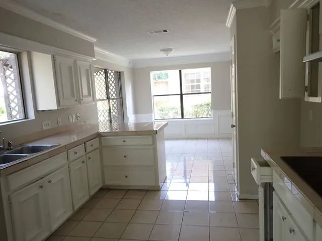 a spacious bathroom with a granite countertop sink a mirror and a bathtub