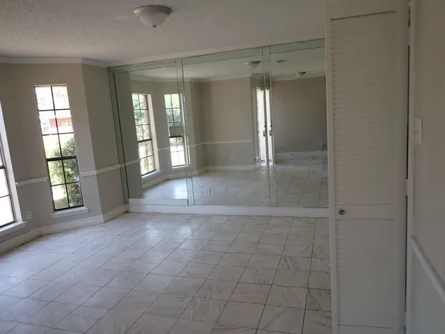 a view of an empty room with a fireplace and a window