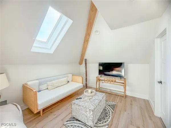 a bed sitting in a spacious bedroom next to a window