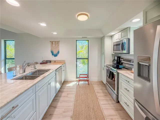a kitchen with stainless steel appliances a stove a refrigerator and a microwave