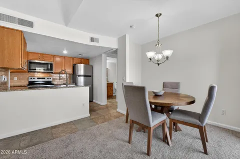 a view of kitchen with refrigerator stove dining table and chairs