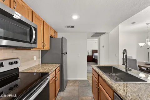 a kitchen with stainless steel appliances granite countertop a sink stove and refrigerator