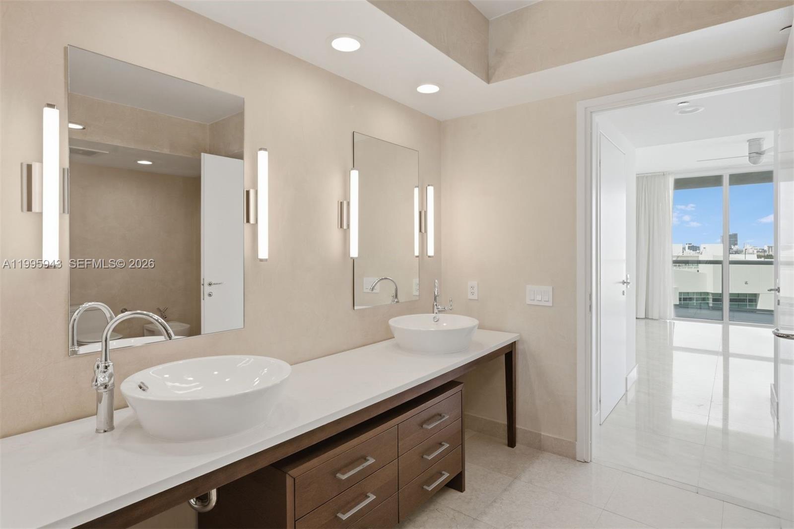 450 Alton Road, Unit 910 Miami Beach, FL 33139 - Photo 12 of 59 a bathroom with a double vanity sink and mirror