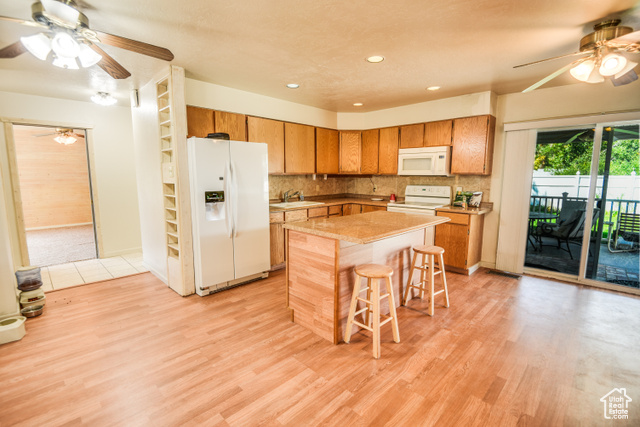 2373 East 190 North Beaver, UT 84713 - Photo 29 of 54 Kitchen with ceiling fan, white appliances, tasteful backsplash, a breakfast bar area, and recessed lighting