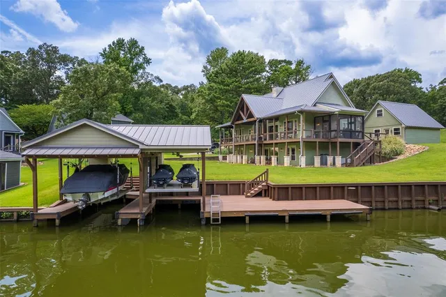 an aerial view of a house with swimming pool a patio and lake view