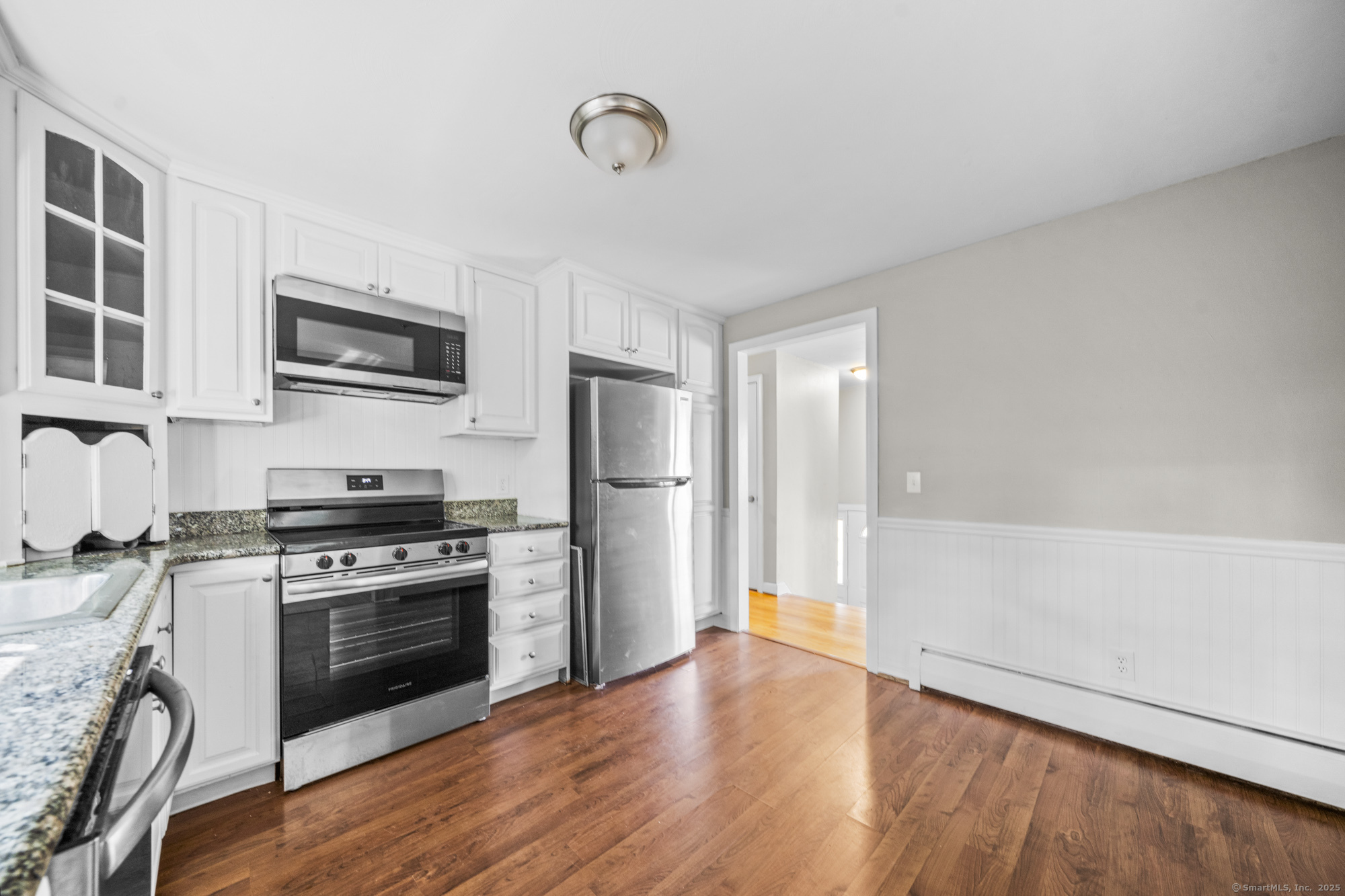779 Bridge Street Suffield, CT 06078 - Photo 10 of 35 a kitchen with granite countertop a refrigerator a stove top oven a sink dishwasher and wooden floor