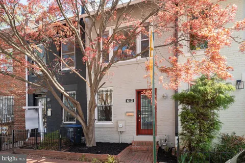 a front view of a building with trees