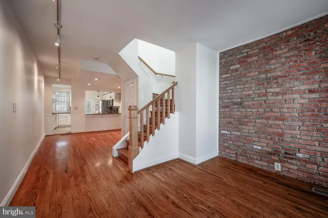 a view of entryway and hall with wooden floor