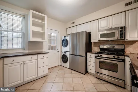 a kitchen with cabinets stainless steel appliances and a window