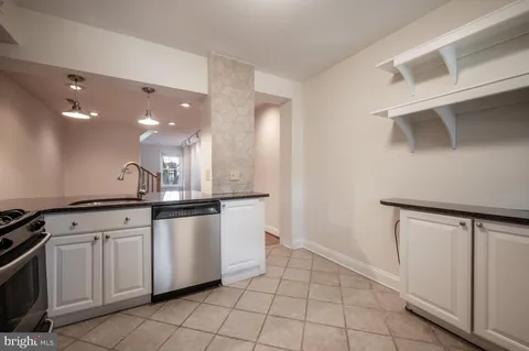 a large white kitchen with a sink and dishwasher a stove with cabinets