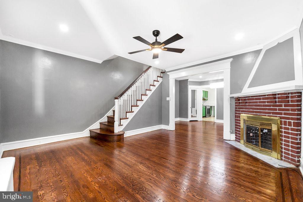 214 Kingston Road Upper Darby, PA 19082 - Photo 5 of 23 a view of an empty room with wooden floor a fireplace and a window