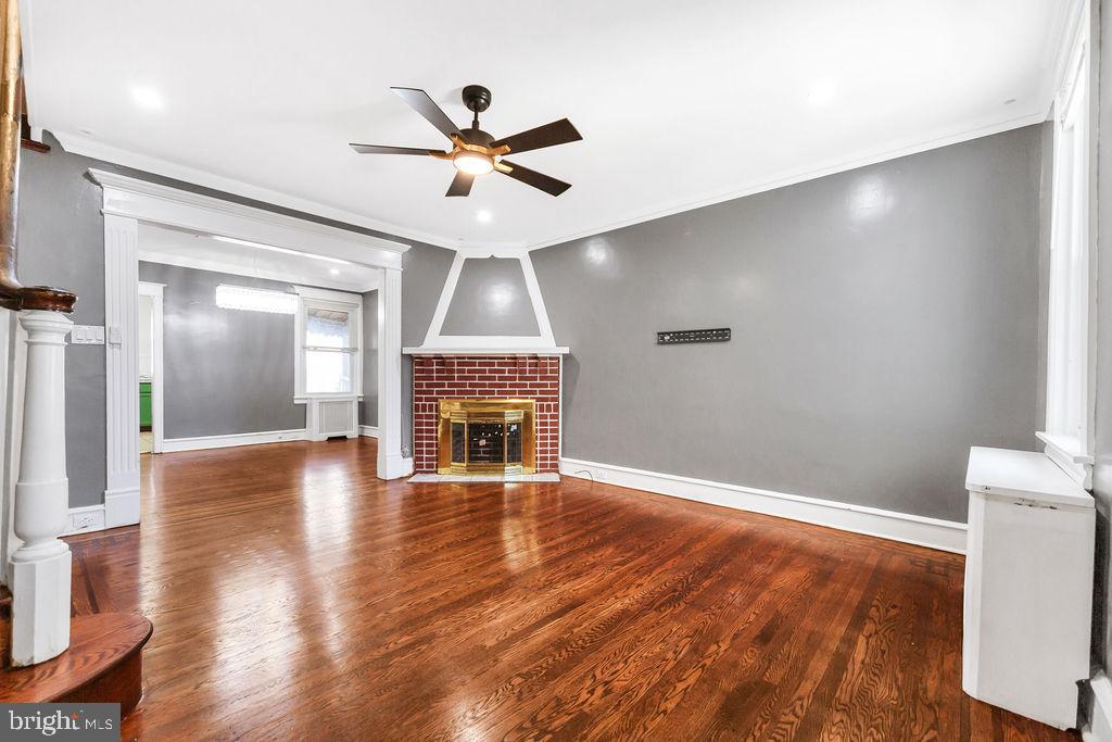 214 Kingston Road Upper Darby, PA 19082 - Photo 6 of 23 a view of an empty room with wooden floor and a fireplace
