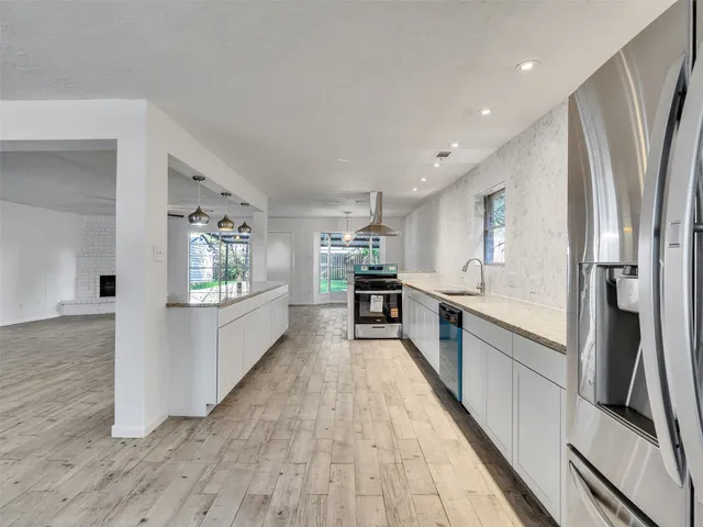 a kitchen with granite countertop a stove a sink and a microwave