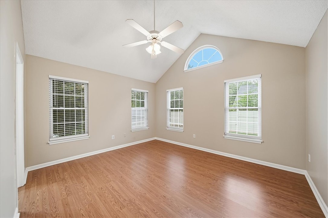 101 Grand Oak Circle Pendleton, SC 29670 - Photo 24 of 40 A spacious bedroom showcasing a vaulted ceiling and ample natural light from multiple windows.