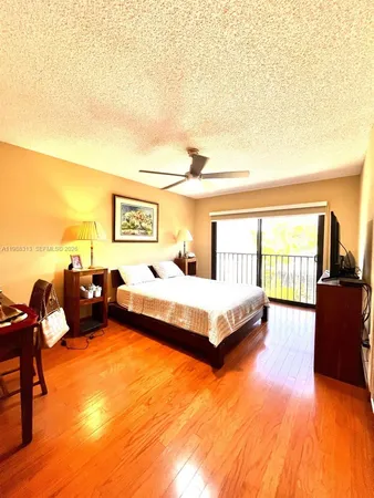 a spacious bedroom with a bed and wooden floor