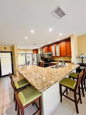 a view of a kitchen with kitchen island a dining table and chairs