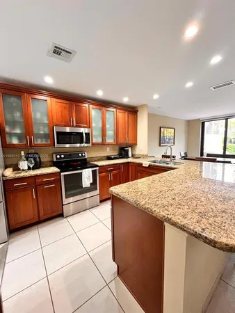 a kitchen with stainless steel appliances granite countertop a stove top oven a sink a counter top space and cabinets