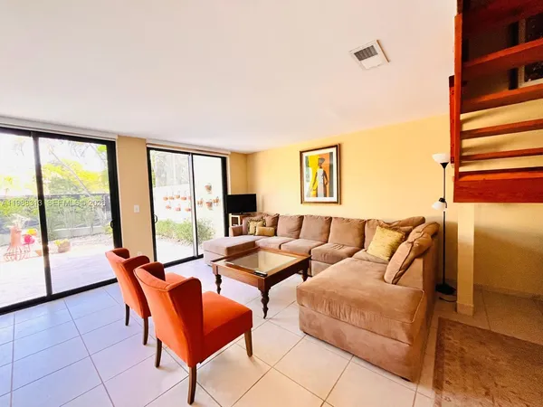 a living room with furniture and a floor to ceiling window