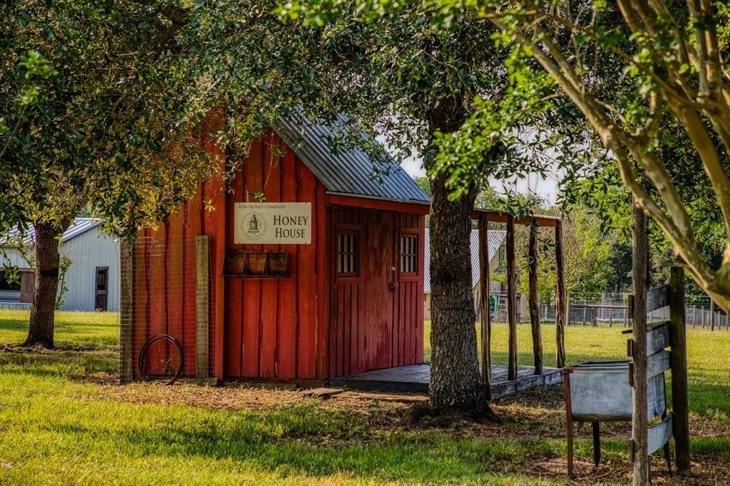 6900 Schroeder Road Brenham, TX 77833 - Photo 22 of 31 a view of a backyard with large trees and wooden fence