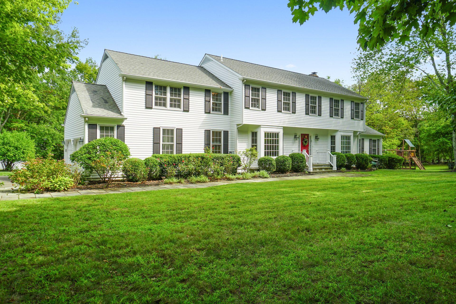 231 Ponus Ridge Road New Canaan, CT 06840 - Photo 36 of 37 a front view of a house with a yard and trees