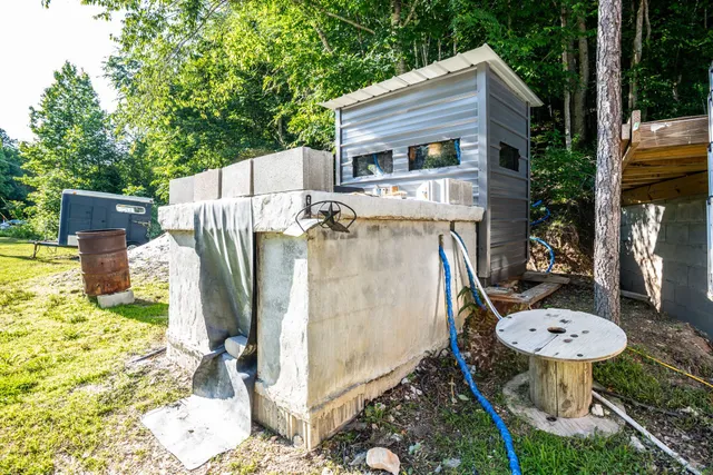 a front view of a house with a garden and trees