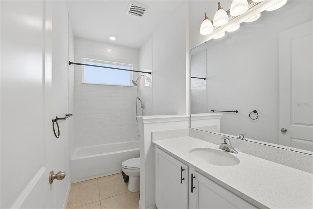 6550 Barnstorm Way St. Cloud, FL 34771 - Photo 12 of 35 a bathroom with a sink a toilet and a mirror